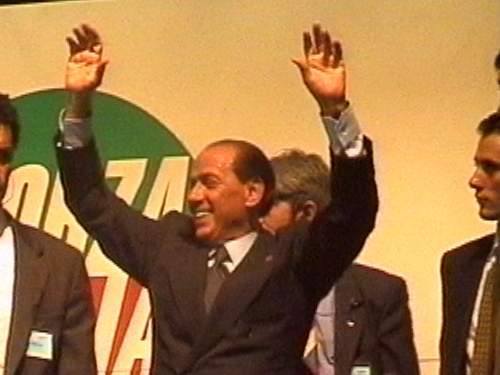 Silvio Berlusconi sorride con le mani in aria